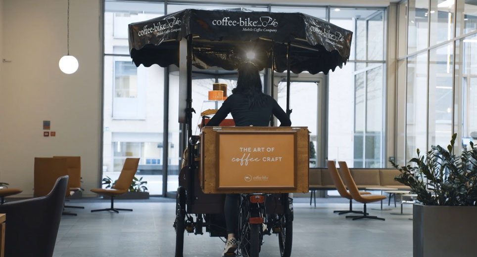 A barista on the Coffee-Bike from the rear view with the slogan The art of coffee craft