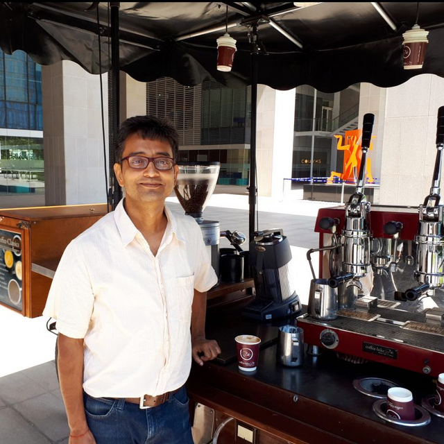 Mann aus Indien steht vor einem Coffee-Bike