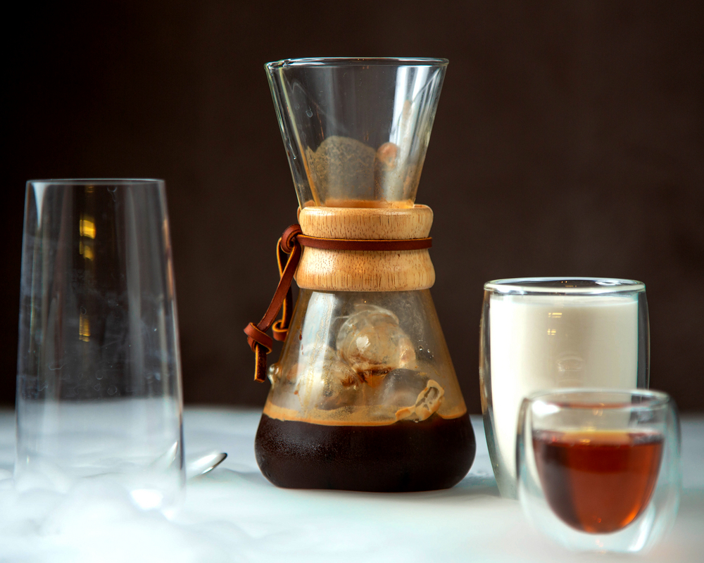 Cold Brew Zubereitung in einem Gefäß mit weiteren Gläsern für die Kaffeevorbereitung. 