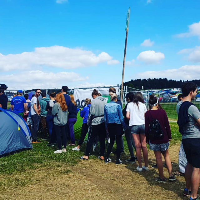 Menschen stehen am Coffee-Bike auf einem Campingplatz in einer Warteschlange.