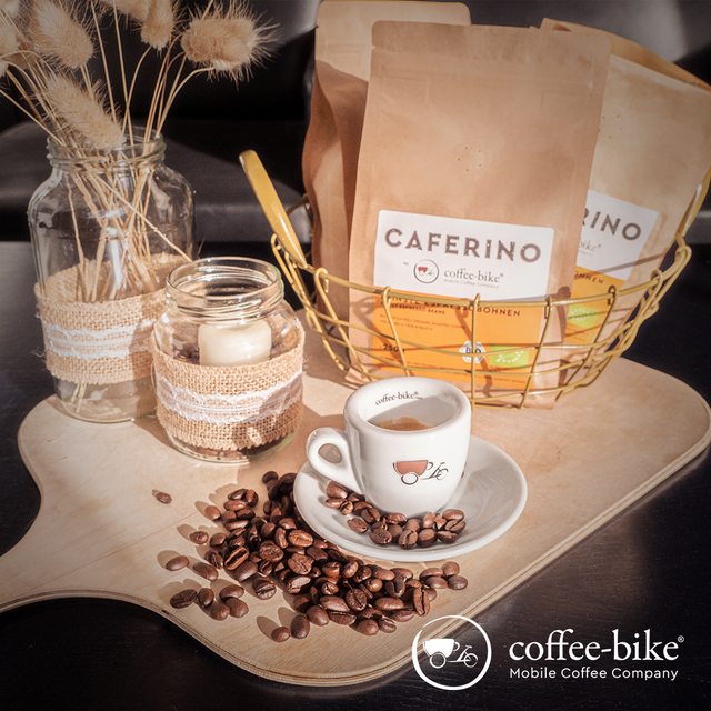 Kerzen, Caferino Bohnen und Espressotasse mit Bohnen auf einem Holzbrett