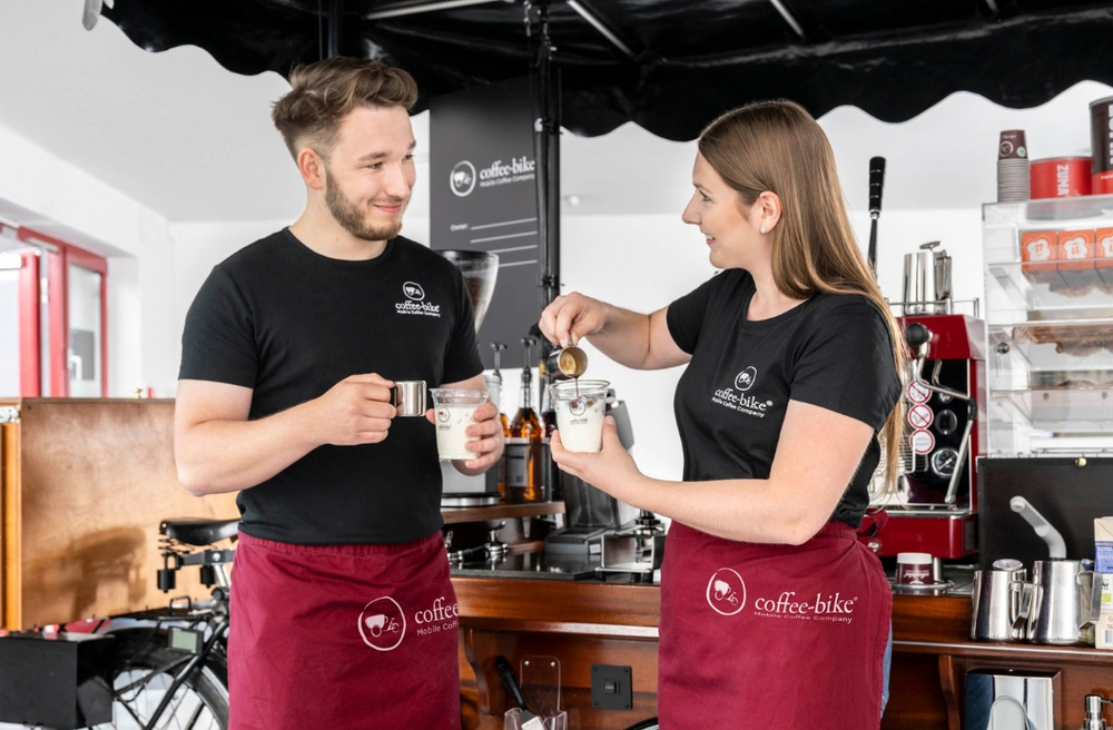 Mann und Frau vor einem Coffee-Bike während eines Kaffeecaterings