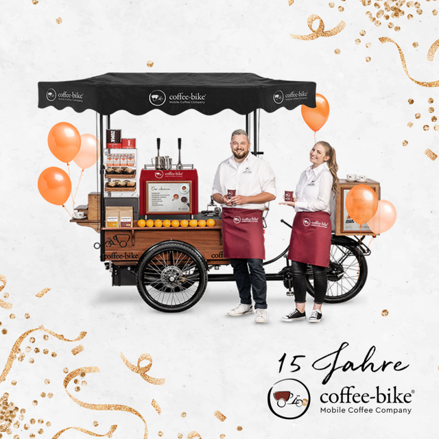 Coffee-Bike Jubiläumsbild mit zwei Barista und einen geschmückten Coffee-Bike.