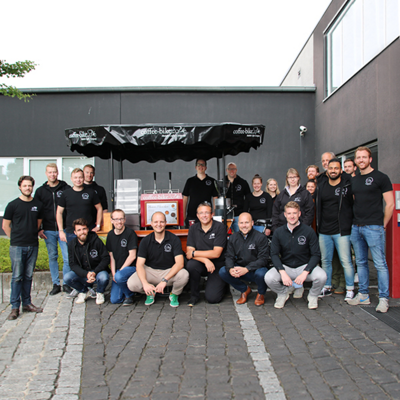 Coffee-Bike employees stand in front of the system headquarters with the 300th Coffee-Bike.