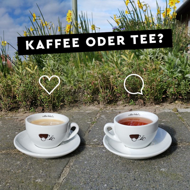 Zwei weiße Coffee-Bike Tassen mit Kaffee und Tee stehen auf einem Steinboden, darüber ein Herz und ein Kommentar Icon, darüber ein schwarzer Balken mit den Wörter Kaffee oder Tee in weißer Schrift