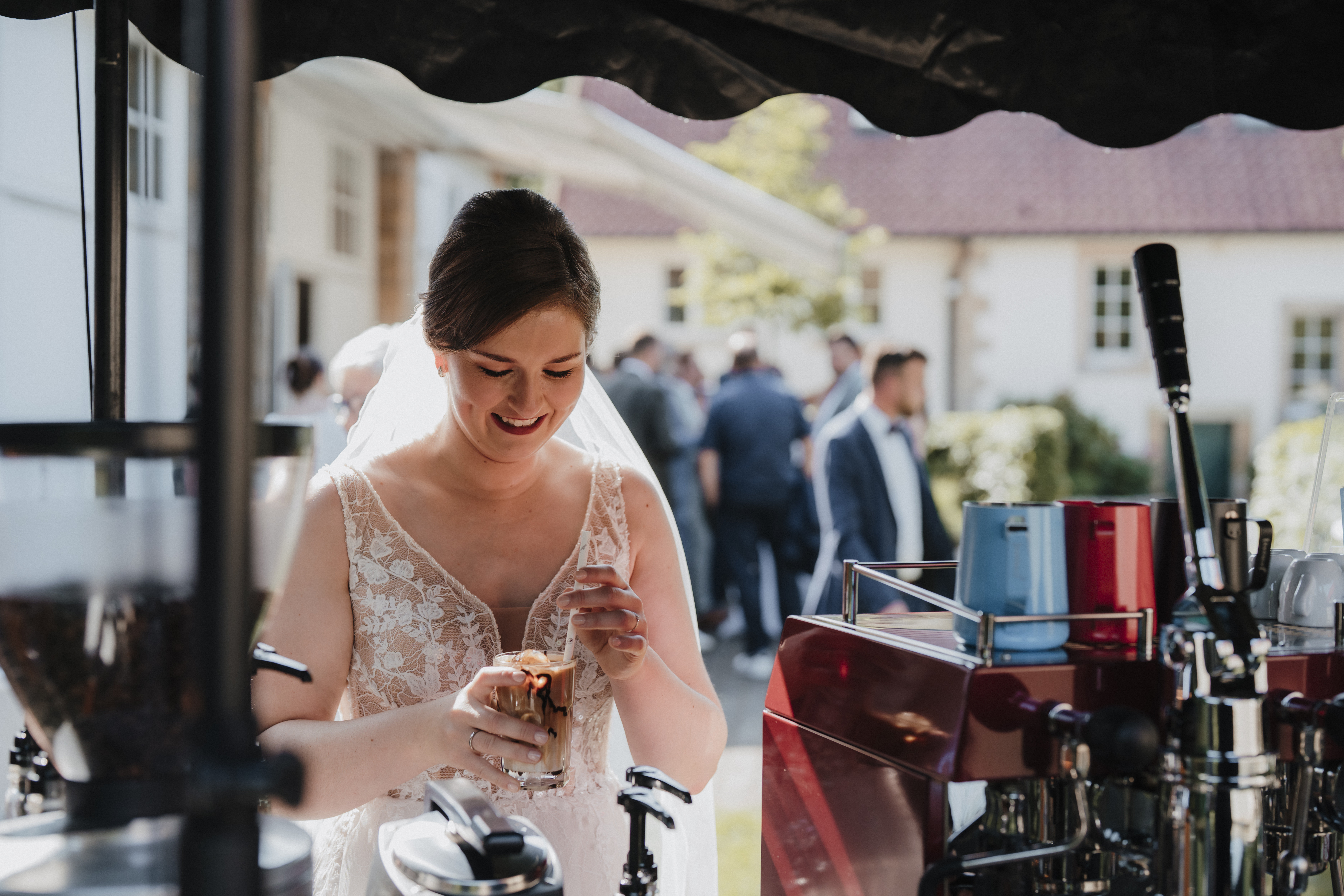 Hochzeitsideen 2026: Braut hält Iced Getränk vor dem Coffee-Bike in der Hand.