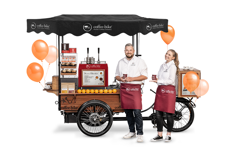 Geburtstags Coffee-Bike mit orangenen Luftballons und zwei feiernden Baristas, die den Kaffee präsentieren