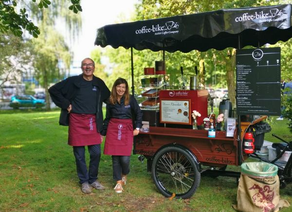 Zwei Coffee-Bike Franchisepartner stehen anlässlich des 15. Geburtstags vor ihrem Coffee-Bike