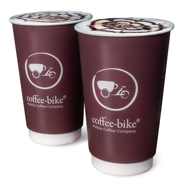 Două pahare de unică folosință XL Coffee-Bike cu coroană din spumă de lapte și decor de ciocolată