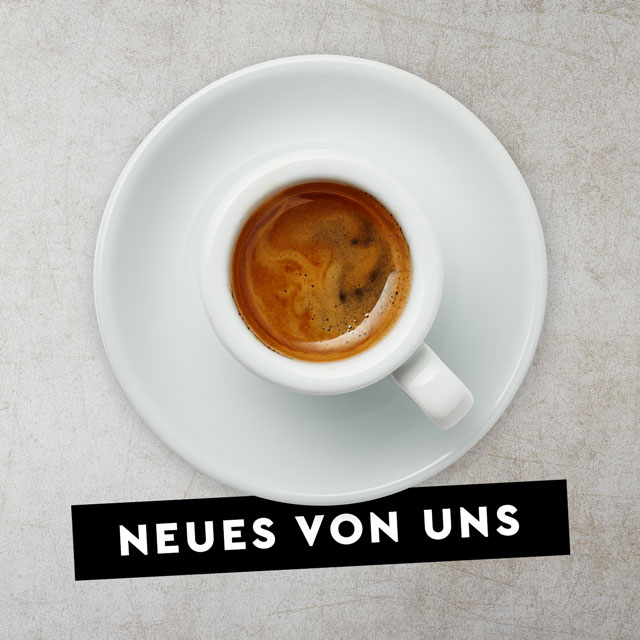Weiße Tasse mit Espresso gefüllt auf grauer Steintextur stehend aus der Vogelperspektive